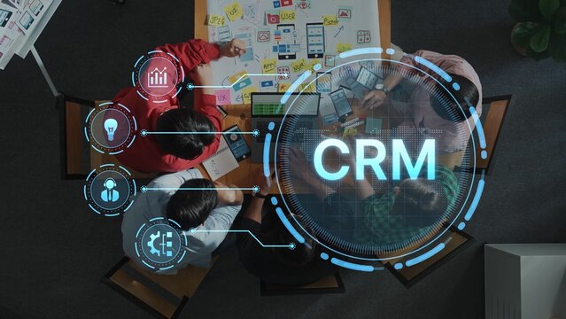 Overhead view of a team working on CRM system development. The digital interface displays concepts, analytics, and project planning tools, enhancing collaboration. Raster - Powered by Adobe