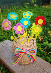 A crochet basket made from colorful jute with flowers