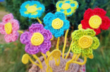 A crochet basket made from colorful jute with flowers