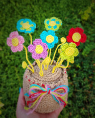 A crochet basket made from colorful jute with flowers