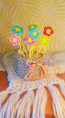 A crochet basket made from colorful jute with flowers