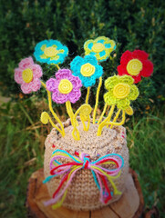 A crochet basket made from colorful jute with flowers