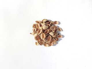 A pile of pistachio shells on a white background