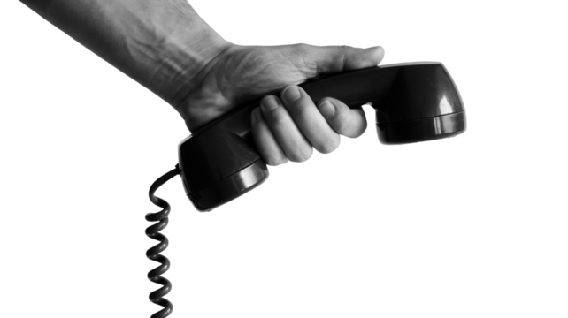 Human hand holding receiver of telephone ready to talk, communications and connection concept