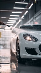 close-up of hand with  hose washing  white car in the garage, car wash 