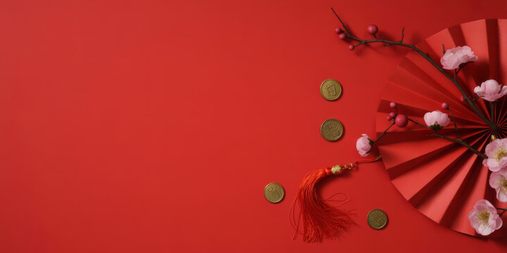 Festive Chinese New Year flat lay featuring a red fan plum blossoms and gold coins for holiday celebrations - Powered by Adobe