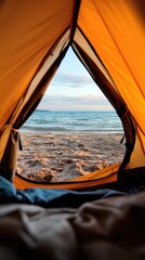 A view from inside a tent looking out at a beach, ocean, and sky. The image is taken during the day, with a warm, inviting mood.