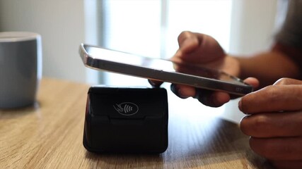 Person paying with smartphone using contactless nfc technology - Powered by Adobe