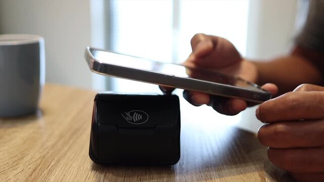 Person paying with smartphone using contactless nfc technology