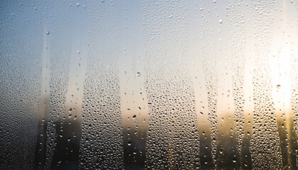 Abstract macro image of clean blue water drops on a transparent glass window surface after a cold rain