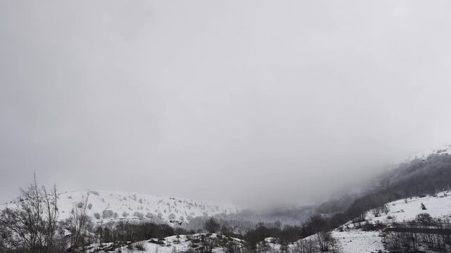 La nebbia scende sulla montagna innevata in autunno