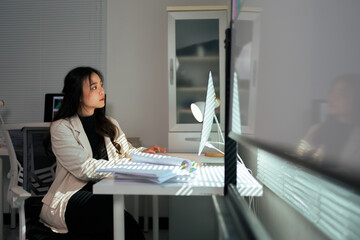 Asian businesswoman reflecting while working in modern office