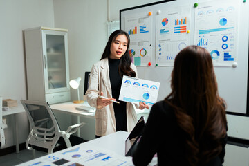 Woman presenting business data charts in office meeting