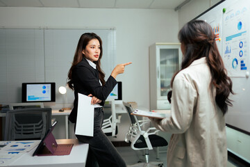 Businesswomen discussing data analysis during corporate office meeting