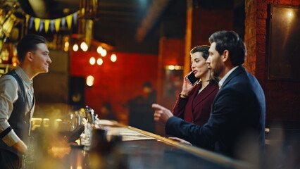 Business pair stepping lounge ordering drink. Guest choosing alcohol beverages