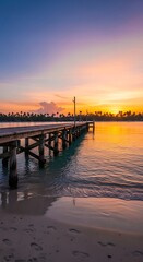 Obraz premium A serene tropical scene featuring a wooden pier extending into calm water under a colorful sunset sky. The beach is pristine