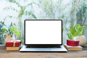 Laptop and gift box and potted plant on wood desk