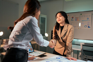 Asian businesswomen concluding successful deal with handshake after meeting