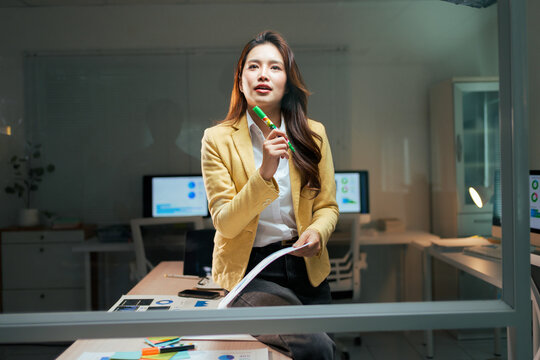 Asian businesswoman thinking planning new strategy late night - Powered by Adobe