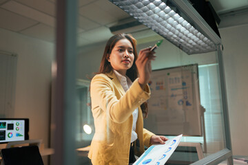 Asian businesswoman writing on glass planning business strategy