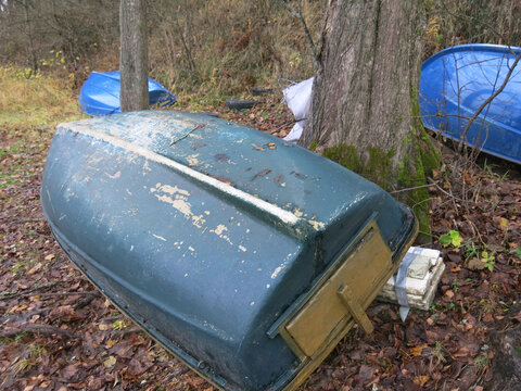 plastic boats on the lake shore in autumn - Powered by Adobe