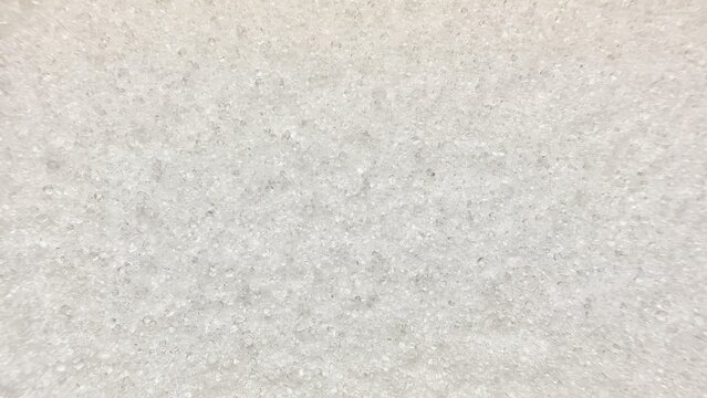 close-up abstract photo of white translucent crystalline granules forming uniform textured surface on light blue background with soft focus blur - Powered by Adobe