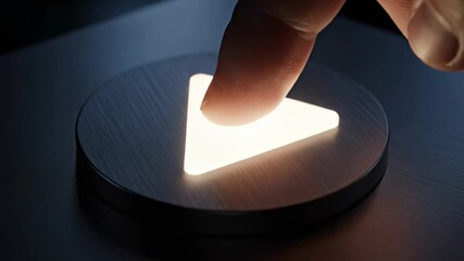 Finger pressing a glowing play button on a dark surface.