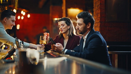 Two strangers flirting bar counter sitting together resting at evening closeup