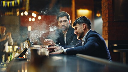Bar clients smoking cigarettes in lounge closeup. Drunk men exchanging words