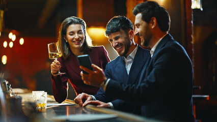 Bar clients looking smartphone enjoying free time in stylish restaurant closeup