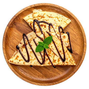 Stacked, folded thin pancakes with chocolate drizzle, mint, on a wooden plate