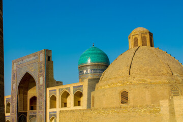 Uzbekistan architecture in Samarkand and Bukhara with intricate mosaics blue domes ancient madrasas Islamic patterns historic monuments vibrant tilework and cultural heritage in bright daylight