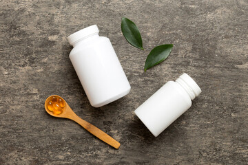 Omega-3 capsules lie in white bottle on a table with green leaves background. Fish oil tablets. Biologically active additives. omega 6, omega 9, vitamin A, E, D, vitamin D3 top view with copy space