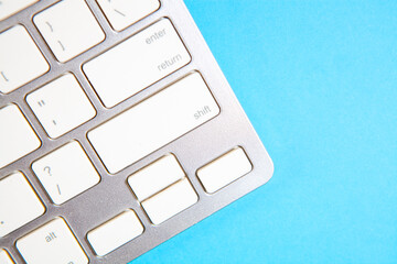Close up of white computer keyboard on blue background with copy space.