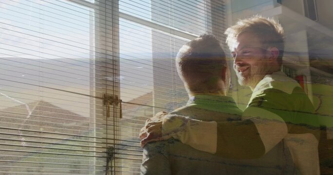 Embracing two men leaning at window with venetian blinds, sunlight, striped sweater, copy space