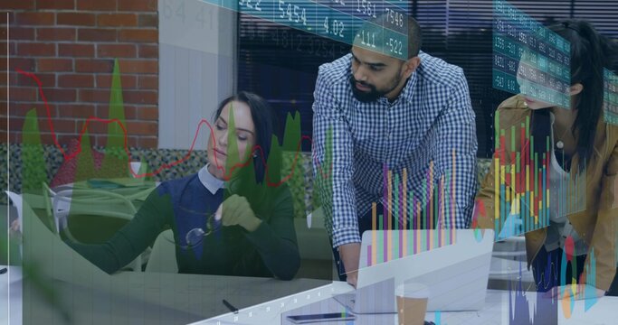 Reviewing team in business casual leaning over laptop at office table, displaying stock charts