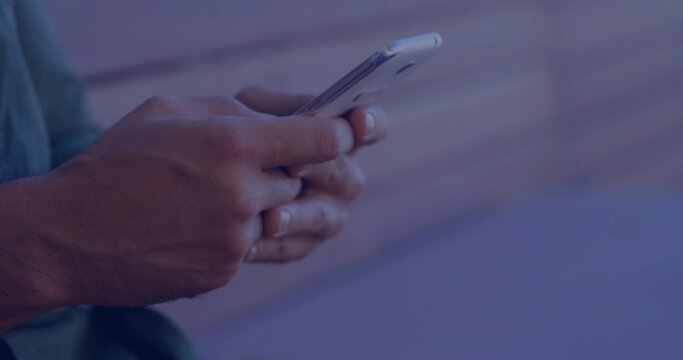 Holding mid-adult male hands tapping smartphone at wooden bench, showing ring and green shirt