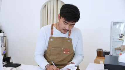 Coffee shop owner man working on bookkeeping and sales report, focused barista reviewing financial data on laptop, representing small business management, daily coffee shop operation with technology - Powered by Adobe