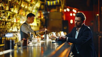 Solo man drinking alcohol sitting bar thinking quietly closeup. Guest paying