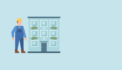 Fototapeta premium Maintenance worker standing by a building decorated for the winter holidays