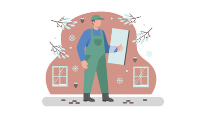 Glazier worker in overalls holding a glass pane for winter home repair or installation service