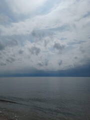 A surreal looking cloudscape with a dreamlike quality sitting over a calm and quiet bay area on a warm summer day.