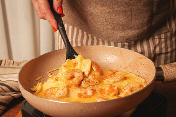 Cooking shrimp omelet in a cozy kitchen with warm colors and simple utensils
