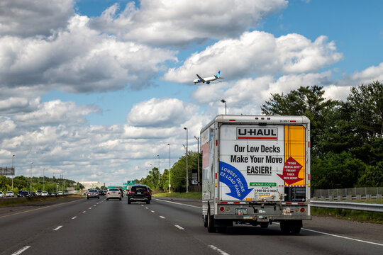 Dulles, USA - May 24, 2025: Sully road 28 highway in Northern Virginia with U-haul truck traffic cars and airplane clouds blue sky
