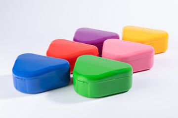 Colorful orthodontic retainer cases for safe and hygienic storage. Durable, portable, and ideal for retainers, mouthguards, or dentures. Colorful plastic containers.