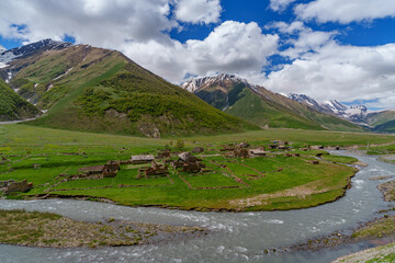 Abandoned riverside village in wide green Caucasus mountain valley