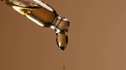 Golden serum dripping from pipette for skin care, offering hydration and a natural glow in this elegant beauty treatment video - Powered by Adobe
