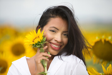 A beautiful mulatto Latin woman with a white shirt brings it close to her face and flirts with a...