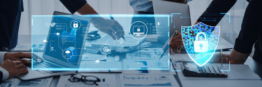 A business team collaborates on a cybersecurity plan in a modern office, utilizing technology and digital protection icons to enhance security strategies and data management. Trope