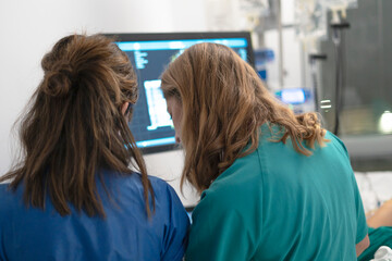 Medical professionals collaborating while monitoring patient data